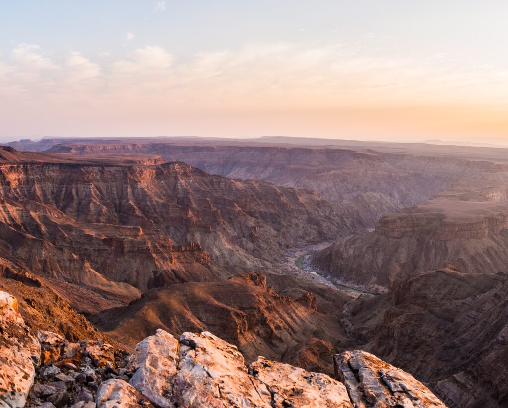 Fish River Canyon, scenic travel destination in Southern Namibia. Last sunlight on the mountain ridges. Wide angle view from above.